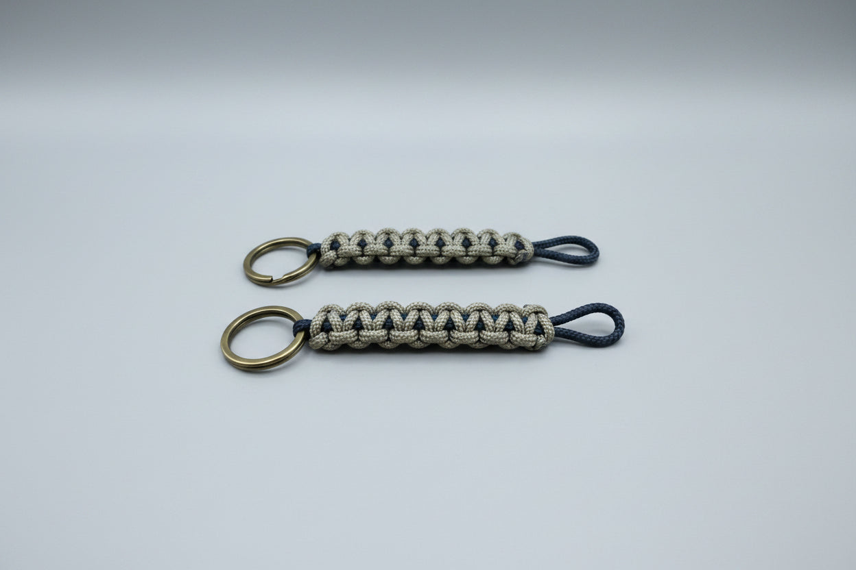 Two paracord keychains on a wooden surface